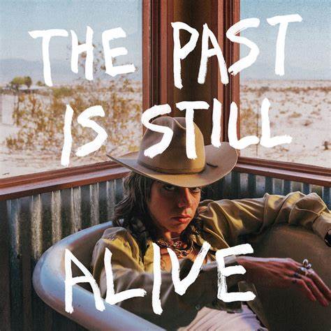 Album cover: person in hat reclining, desert landscape visible through window.