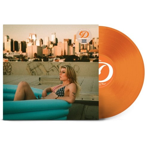 A woman in a bikini sits in a blue inflatable pool before a city skyline.