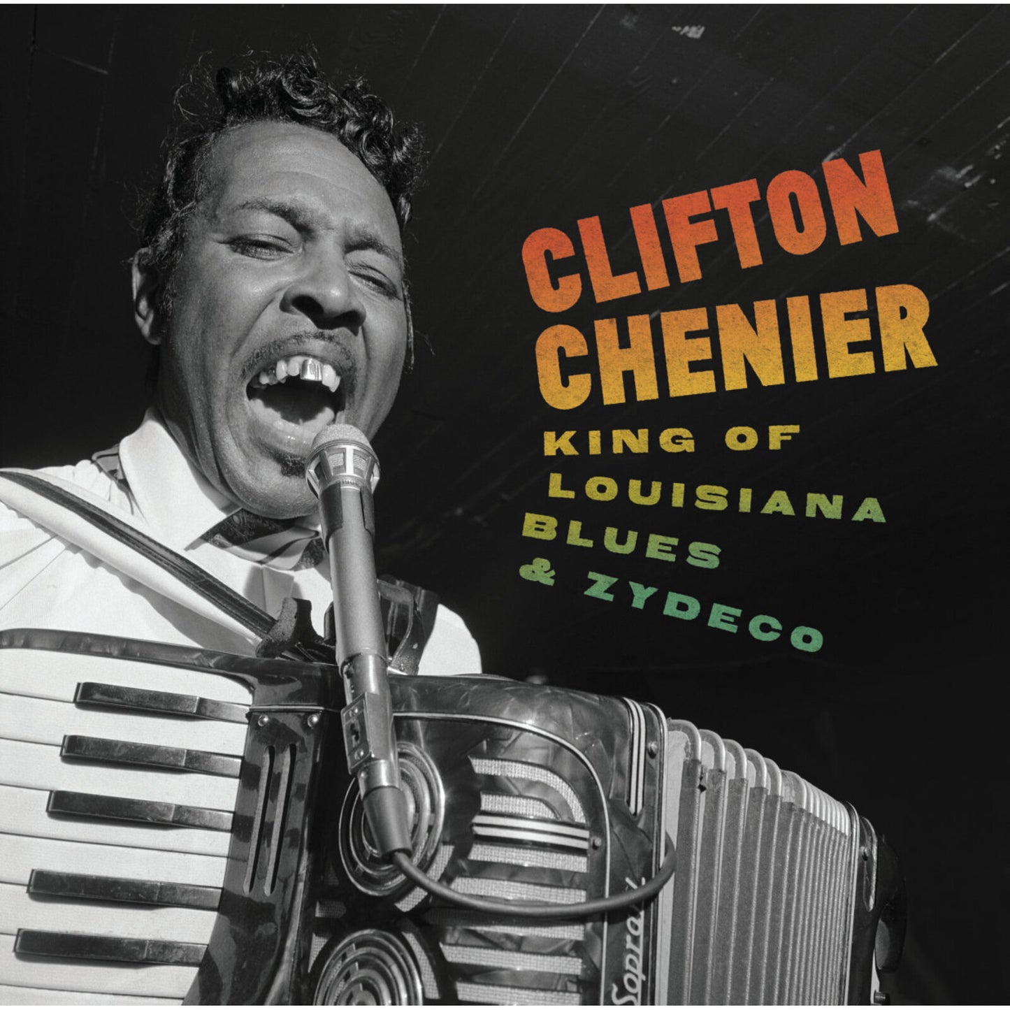 Black and white portrait of Clifton Chenier with an accordion and microphone.