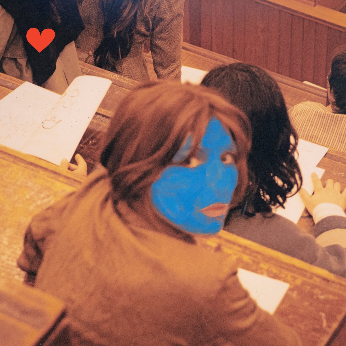 Album cover featuring a person with blue face paint and a red heart.