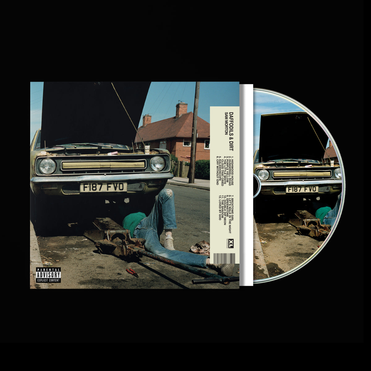 CD cover with a person lying near vintage cars in a suburban setting.