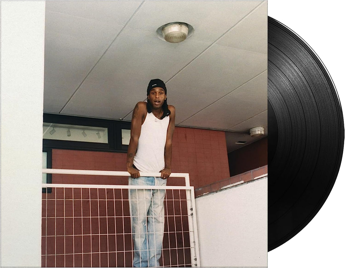 Album cover featuring a man leaning on a metal railing, vinyl record.
