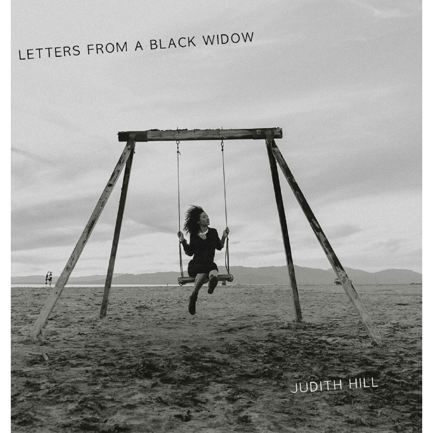 Black and white album cover featuring a woman on a swing set.