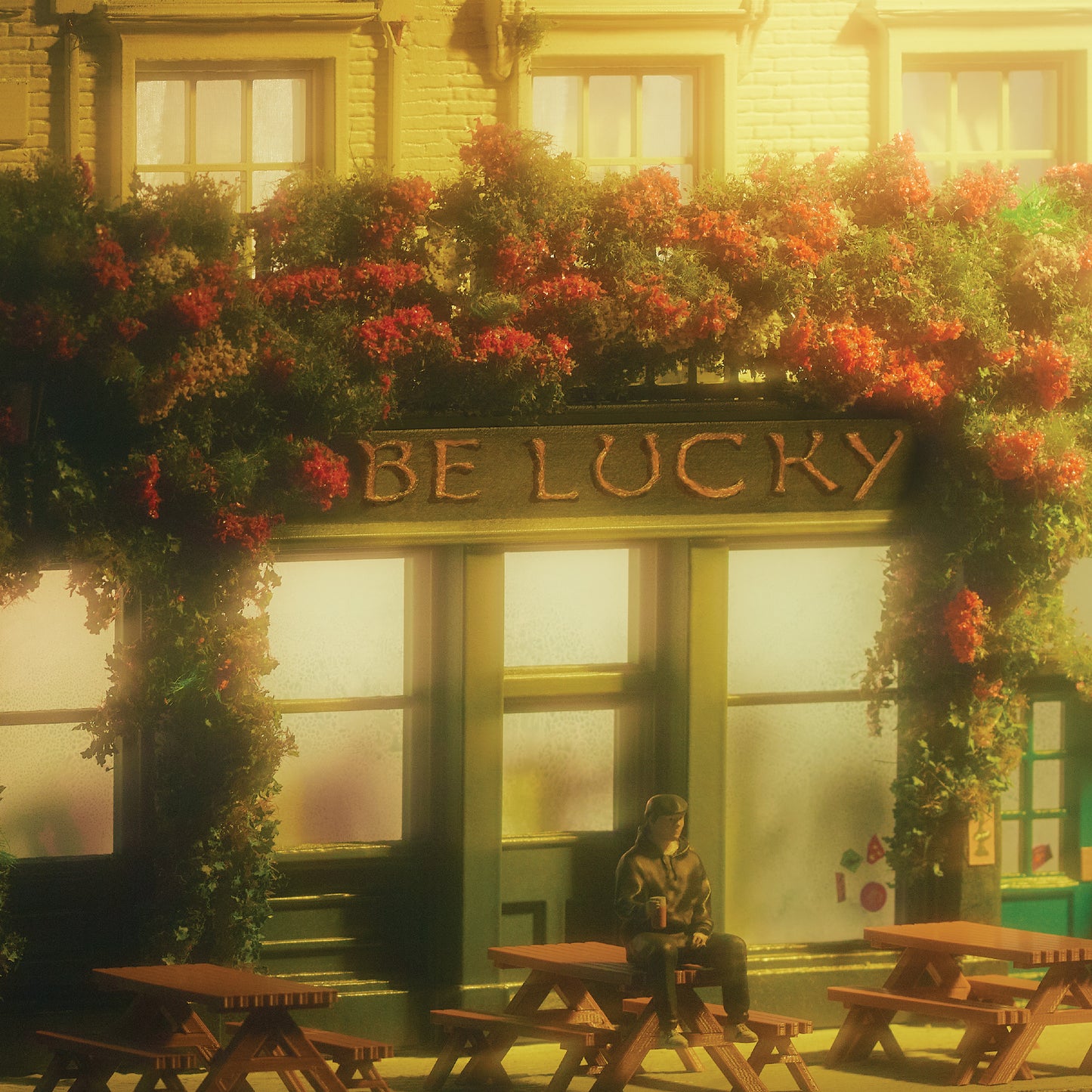 Pub facade with floral decoration, a person seated at tables outside.