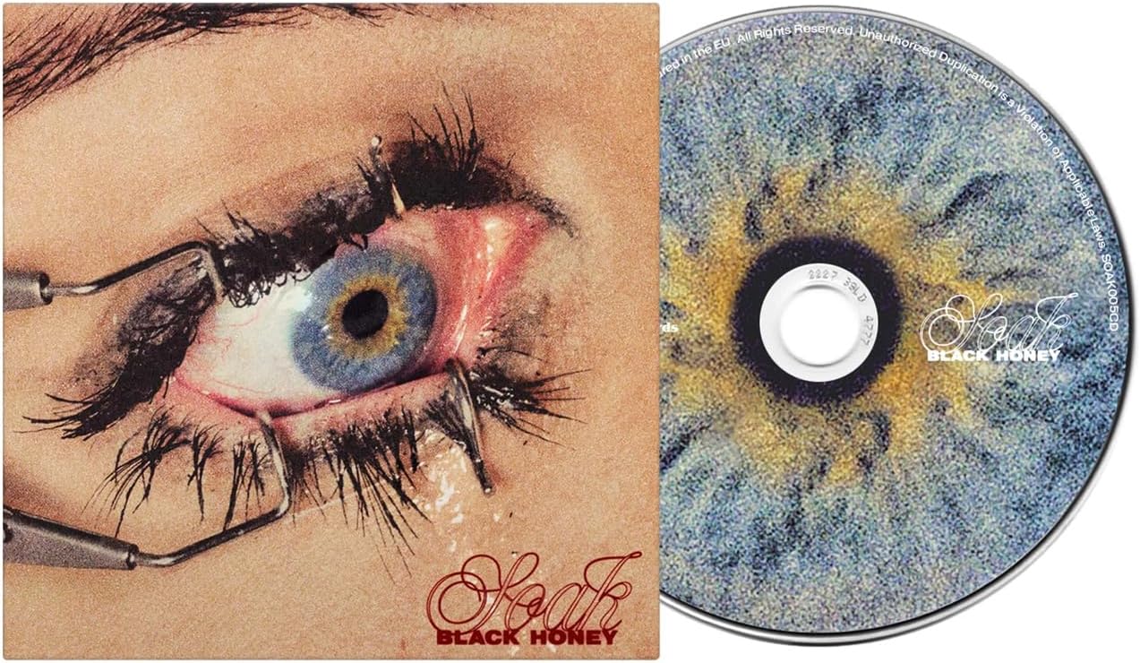 CD cover: close-up of an eye with dark lashes and golden texture.