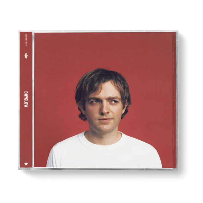 Red CD case featuring a portrait of a young man with brown hair.