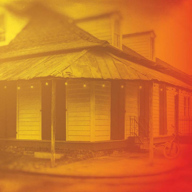 Golden-toned album cover depicting a weathered house with a bicycle.