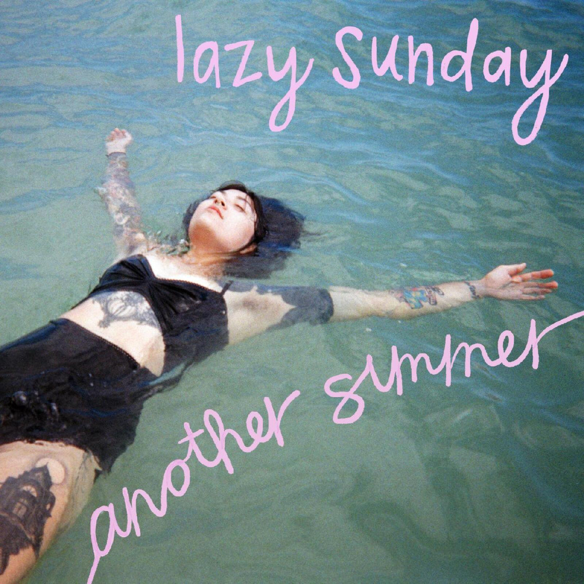 Woman floating in blue water, album cover with pink text.