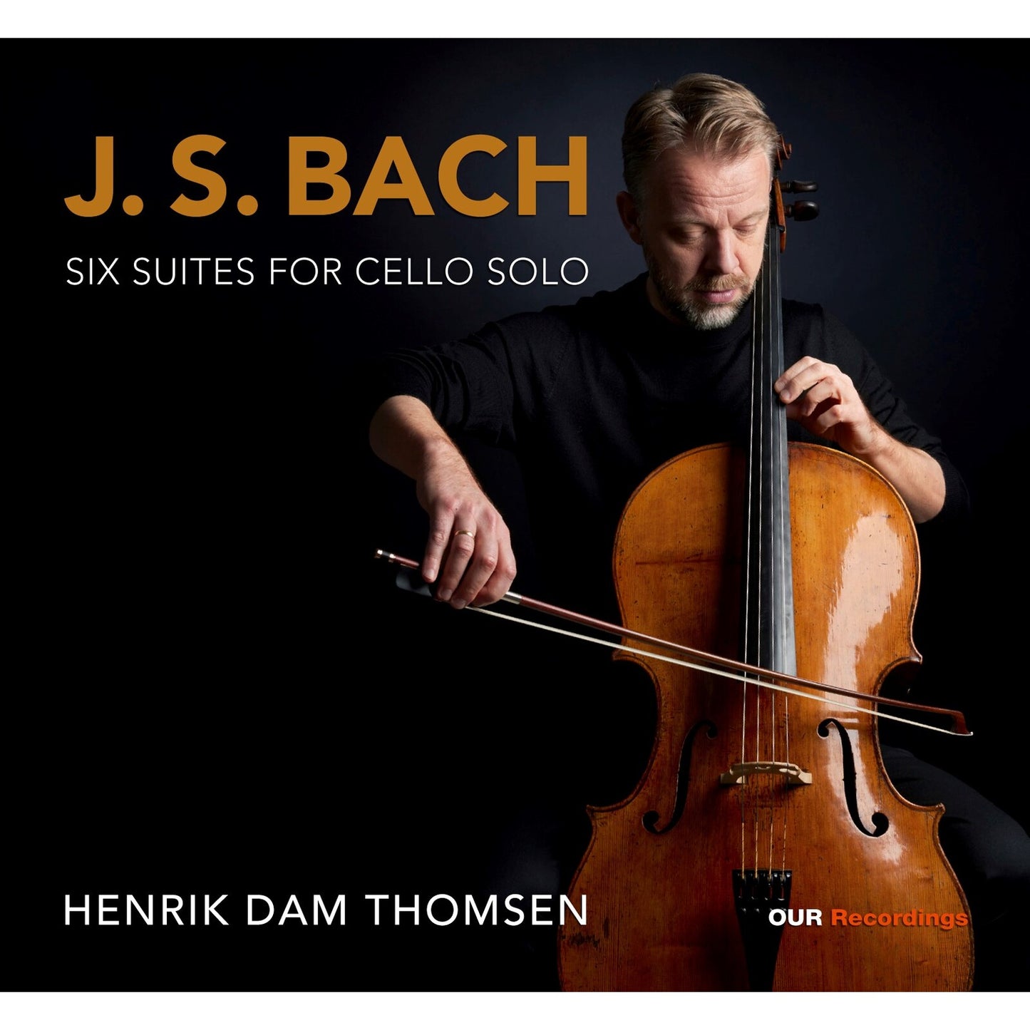 Cellist Henrik Dam Thomsen playing a brown cello against a black background.
