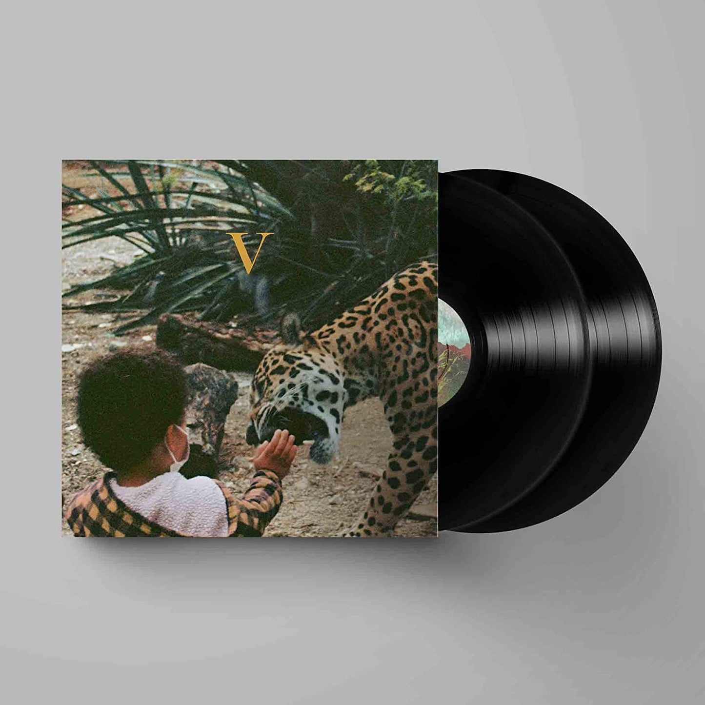 Vinyl record with cover art featuring a child, jaguar, and foliage.