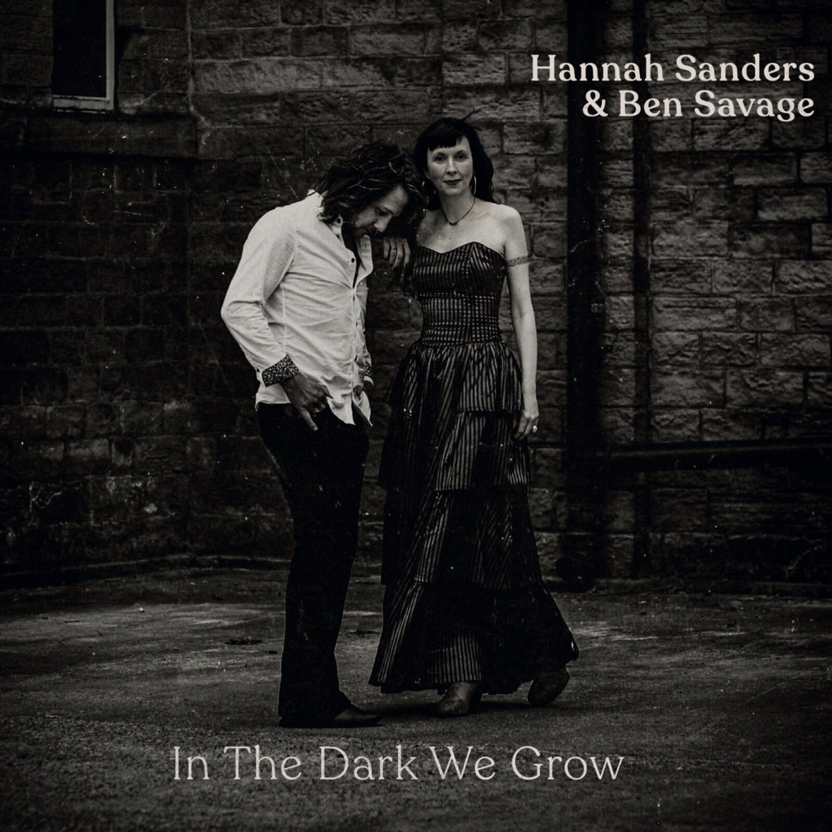 Black and white album cover featuring a couple standing near a stone wall.