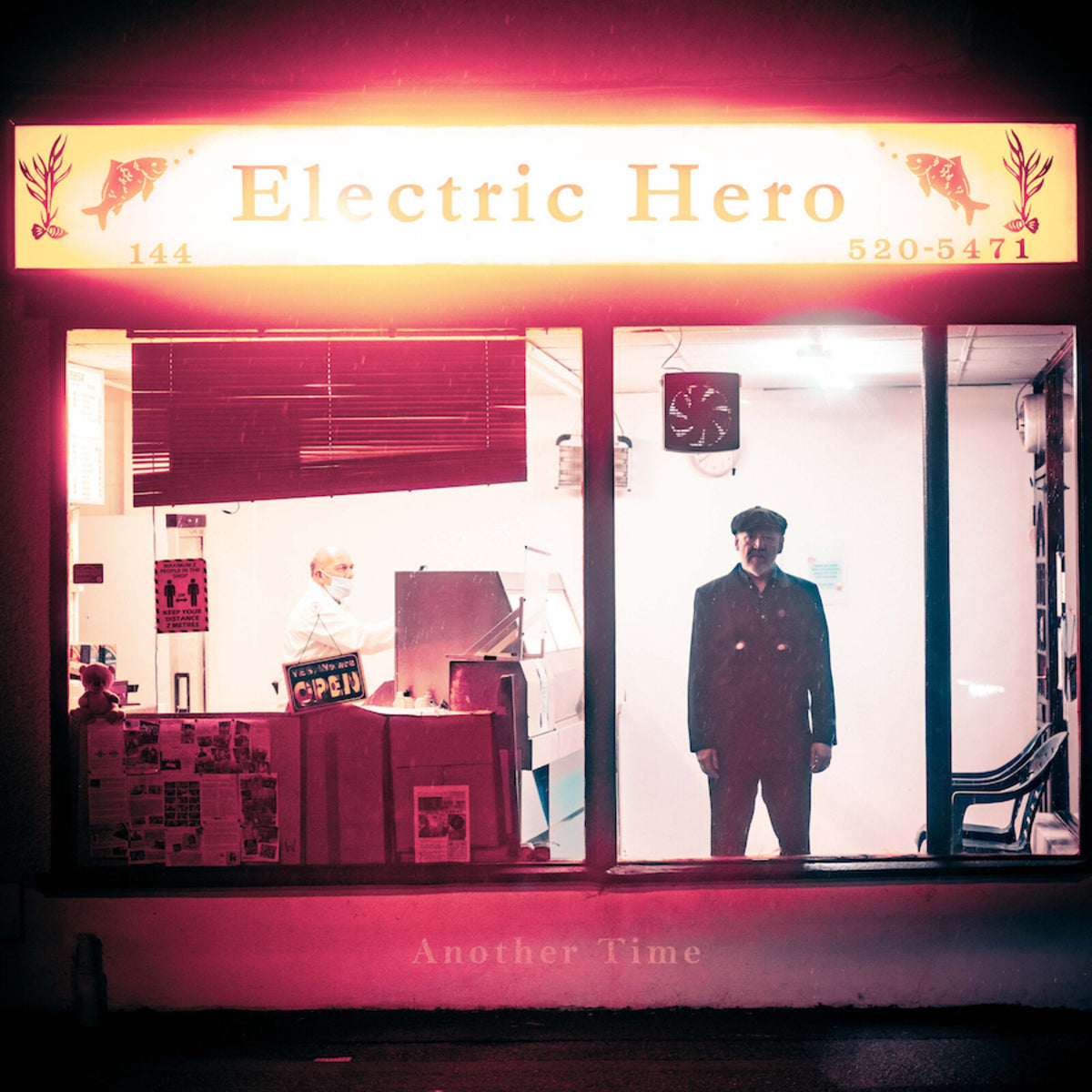 Record store facade with two figures illuminated by a red neon sign.