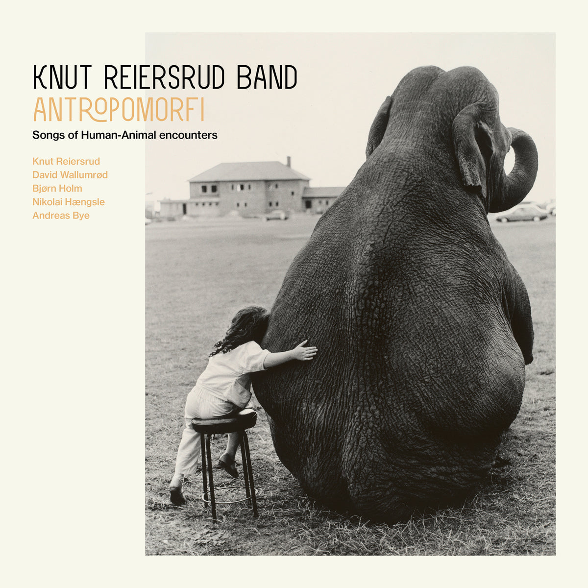 Black and white album cover with a child embracing an elephant.