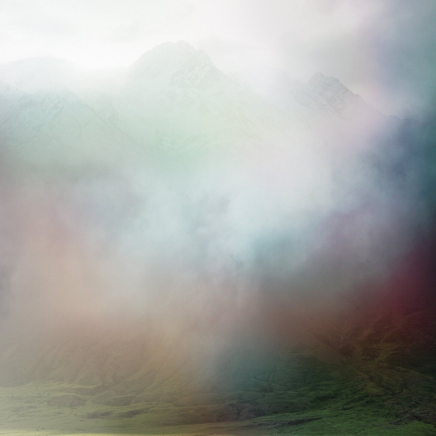 Misty mountains with colorful, blurred gradients of red, green, and blue.