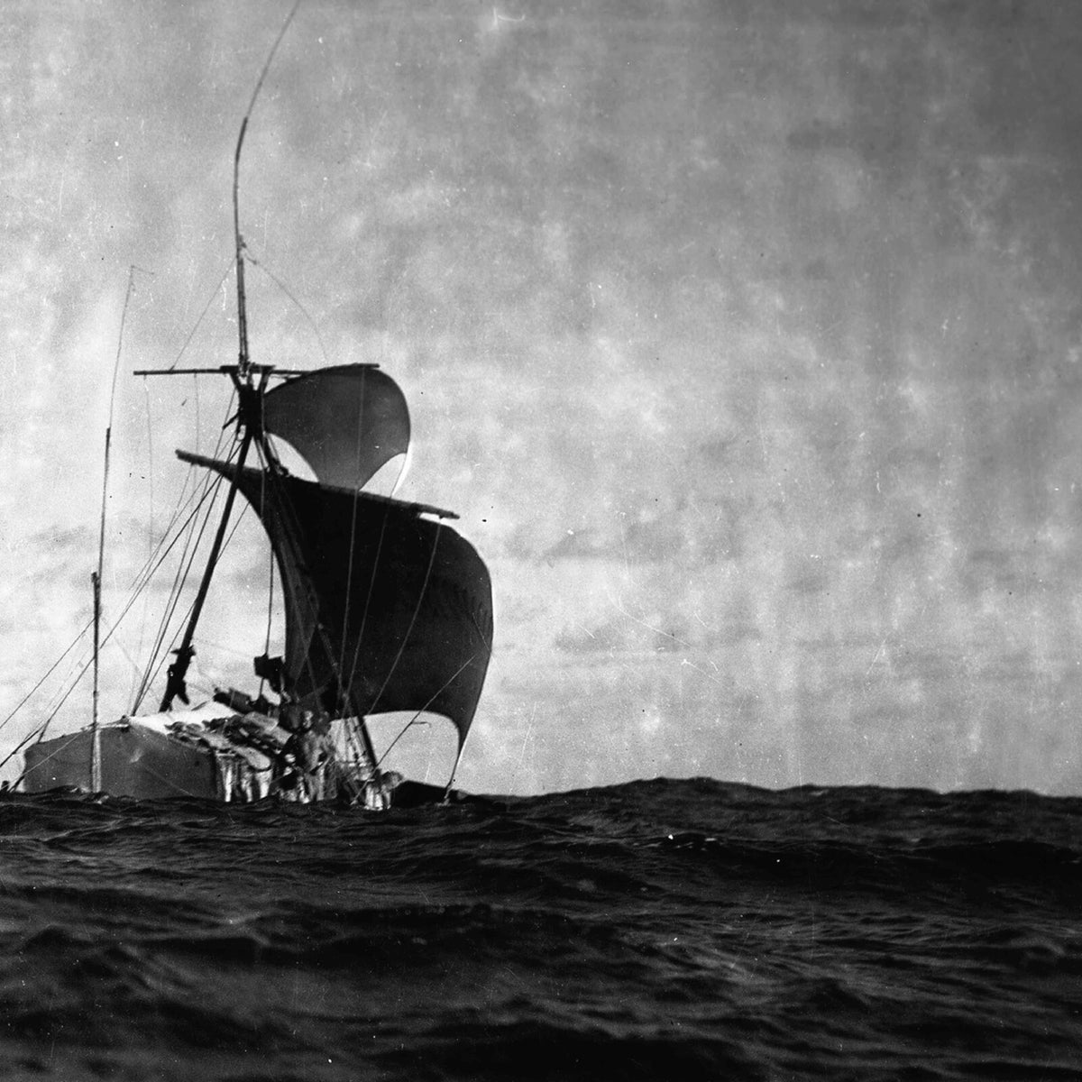 Black and white photo of a sailing ship on choppy water.