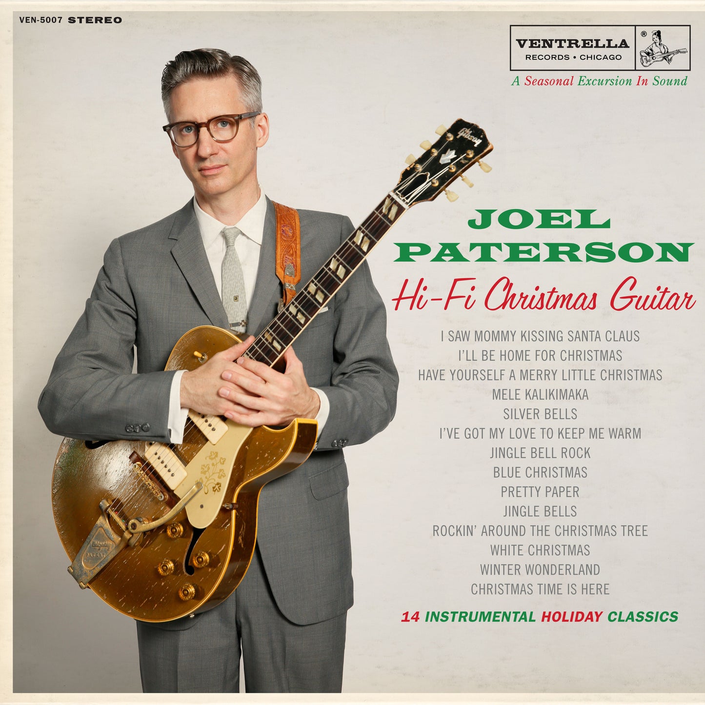Album cover: Joel Paterson with a gold guitar, Christmas music tracklist.