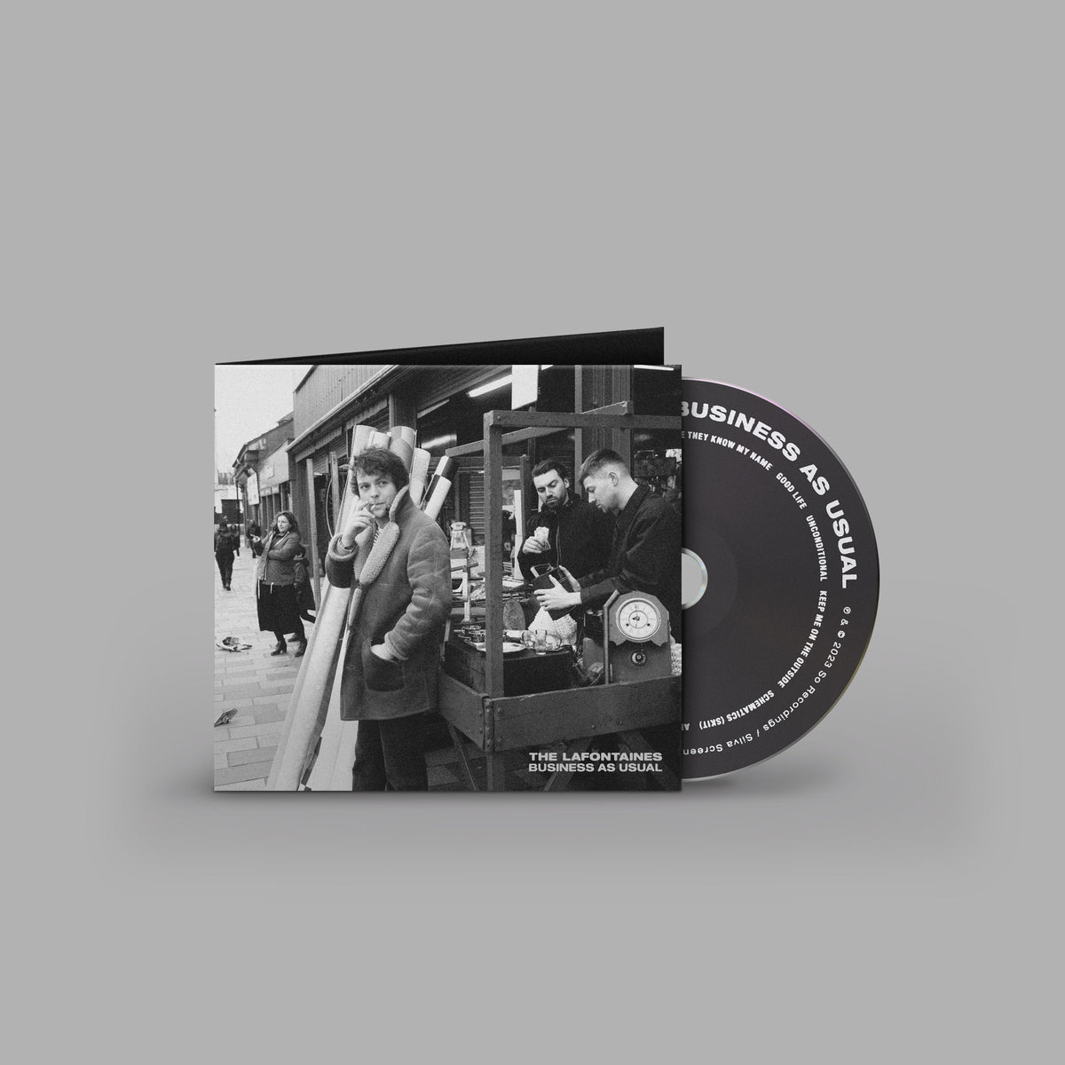 CD case for The Lafontaines’ “Business As Usual” album, black and white.