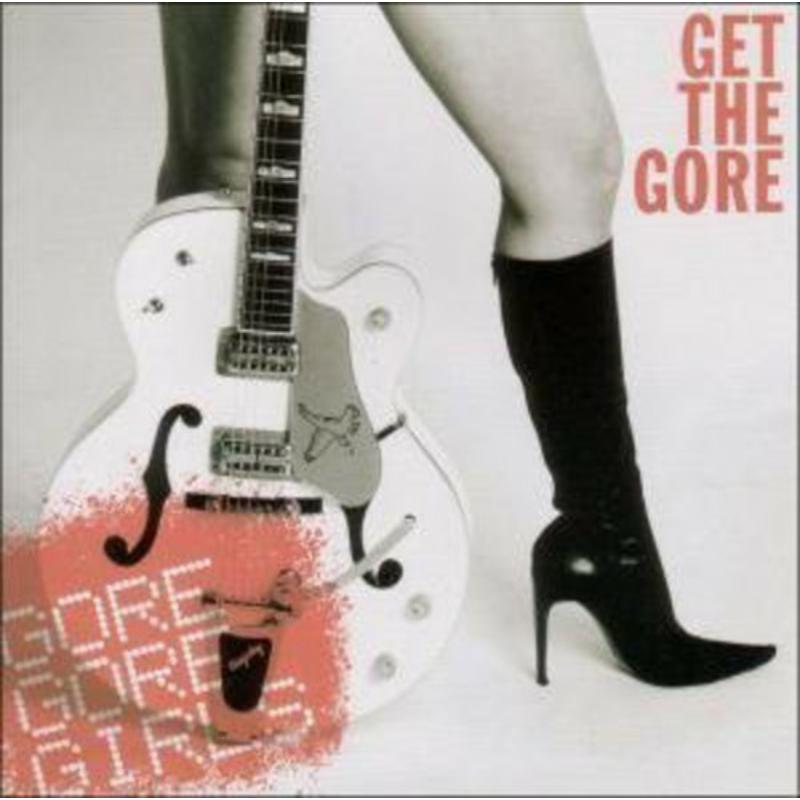 Black and white photo of a white electric guitar and a black high-heel boot.
