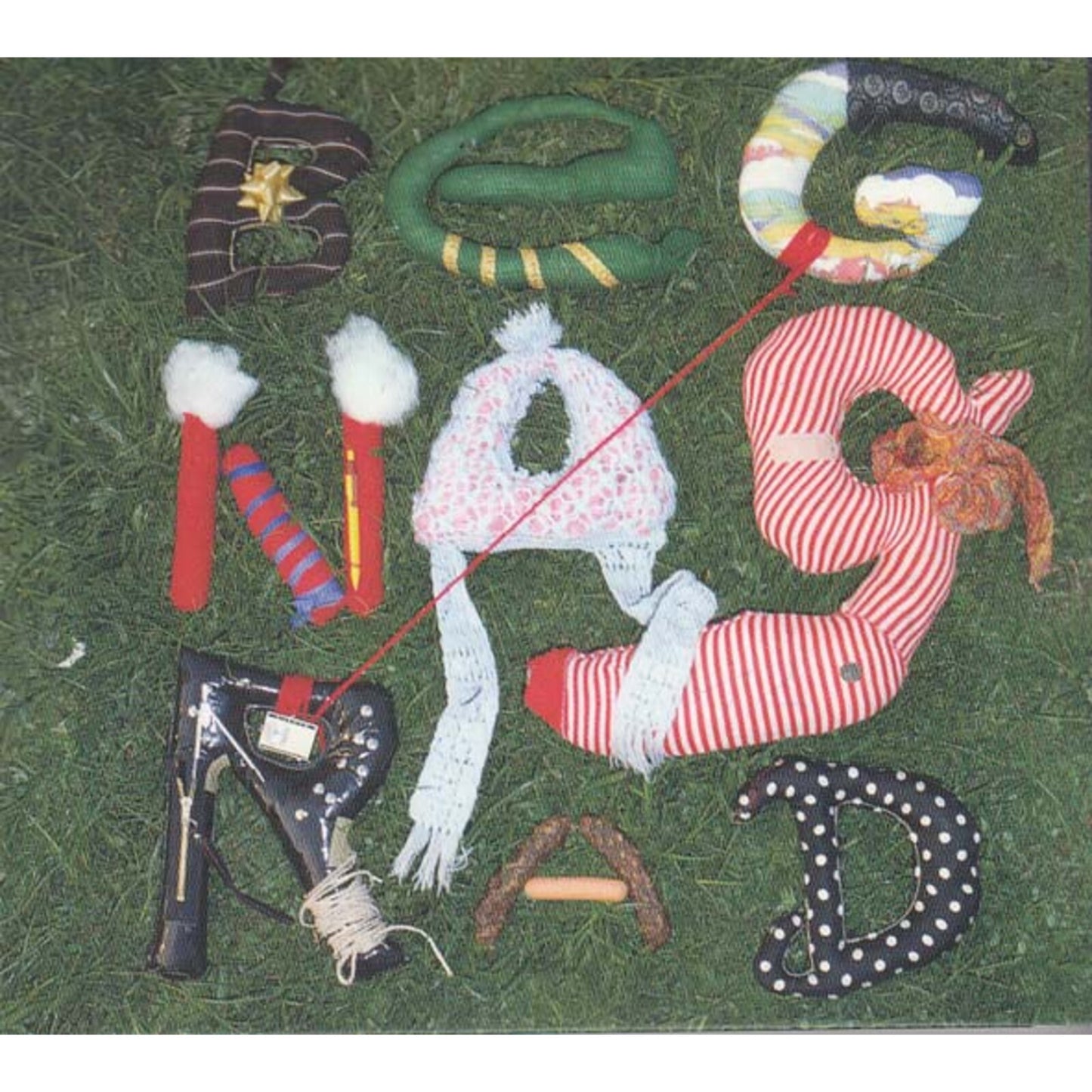 Fabric letters spelling "Begnagrad" arranged on a green, textured surface.