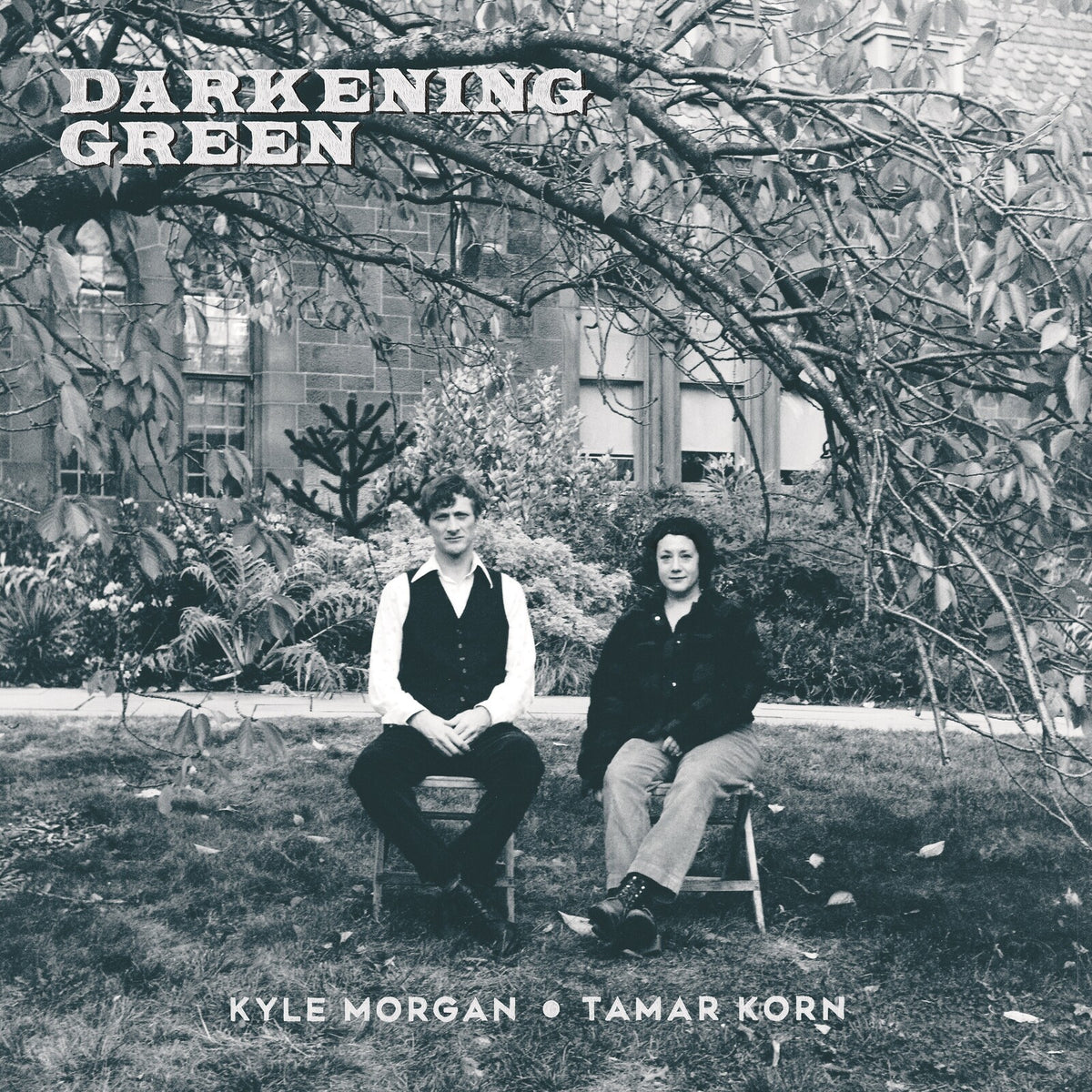 Black and white album cover featuring two people seated in a garden.