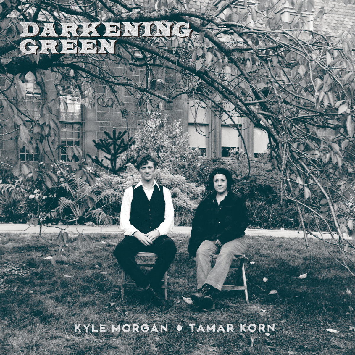 Black and white album cover featuring two people seated in a garden.