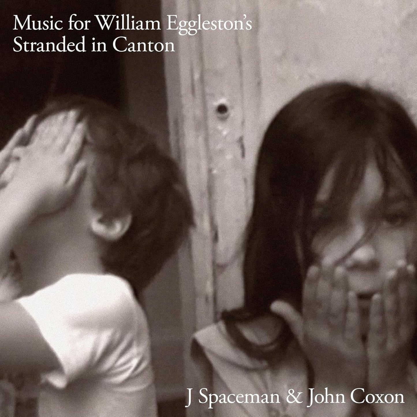 Black and white vinyl album cover featuring two blurred figures indoors.