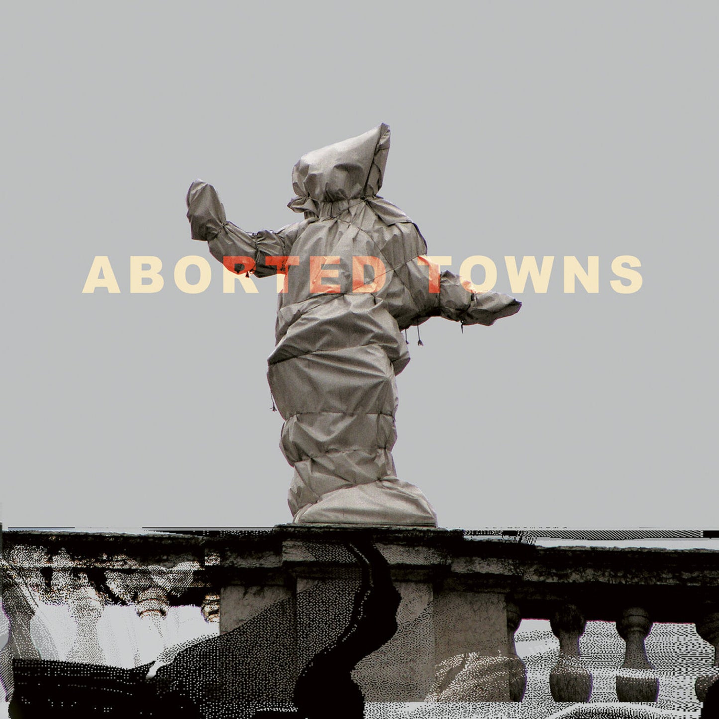 Hooded figure statue on a rooftop, album cover for "Aborted Towns.