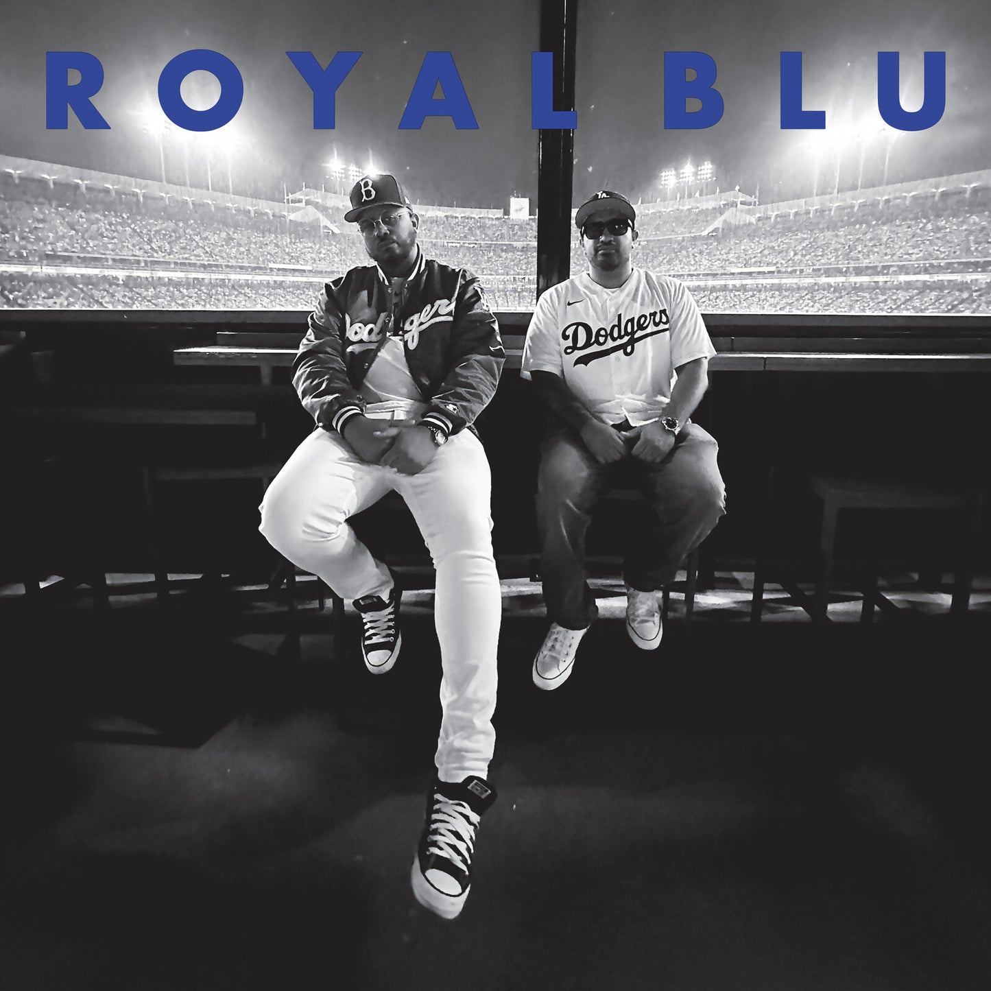 Two men in Dodgers apparel sit before a stadium background with blue text overlay.