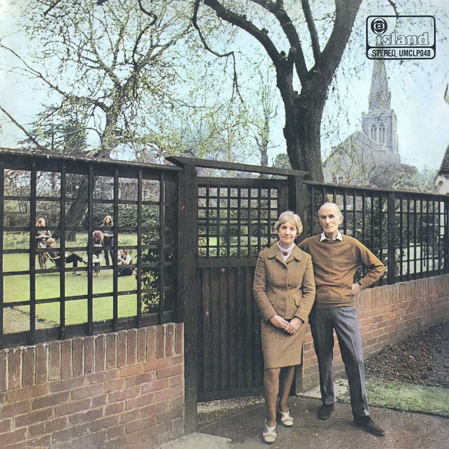 Album cover: couple standing by a fence with a park background.