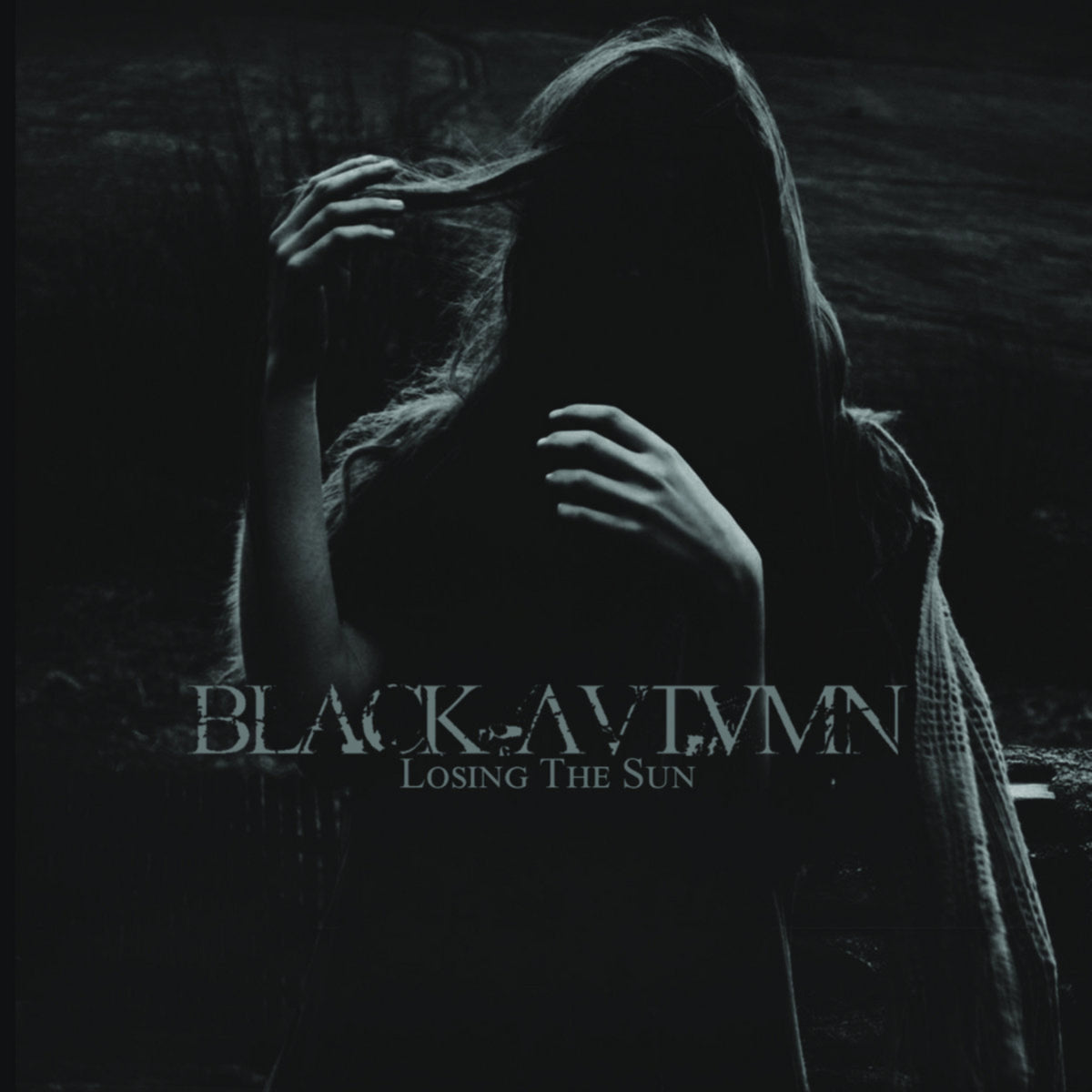 Dark album cover featuring a person with obscured face and hands.