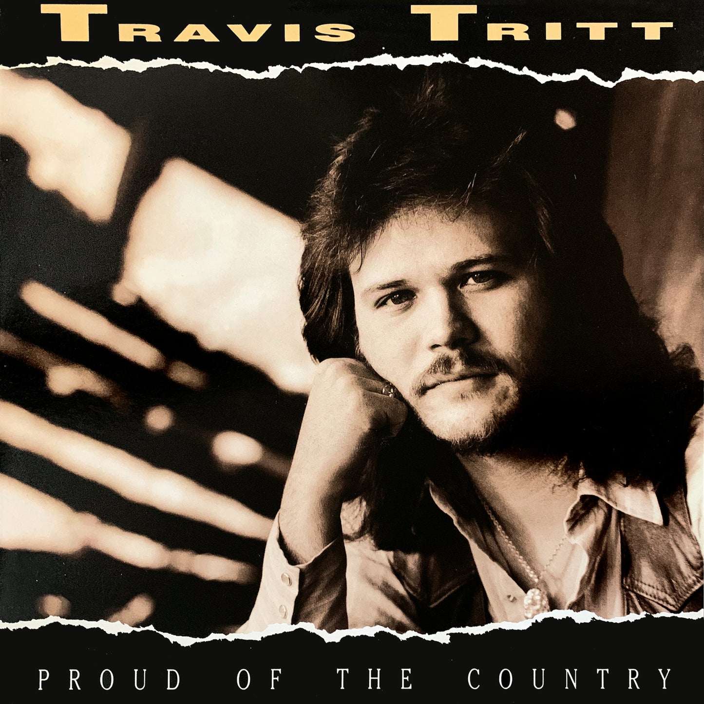 Travis Tritt album cover, "Proud Of The Country," featuring a portrait.