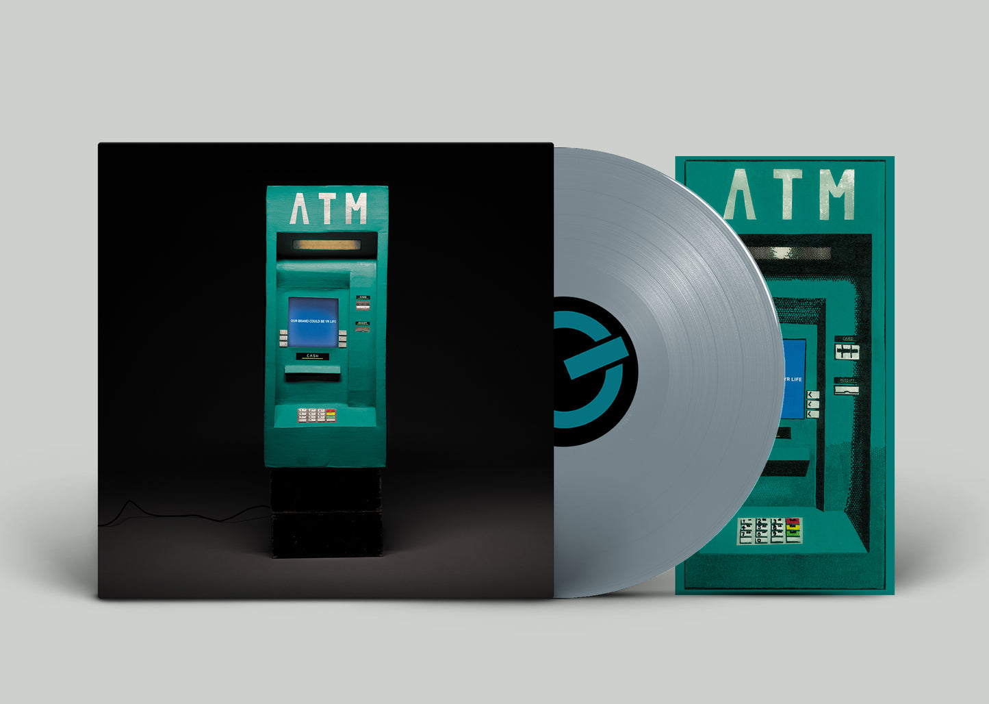 Vinyl record and album cover featuring a teal ATM machine on a black background.