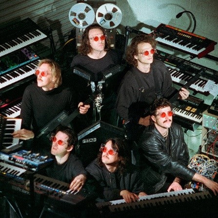 King Gizzard & The Lizard Wizard band members wearing red sunglasses at keyboards.
