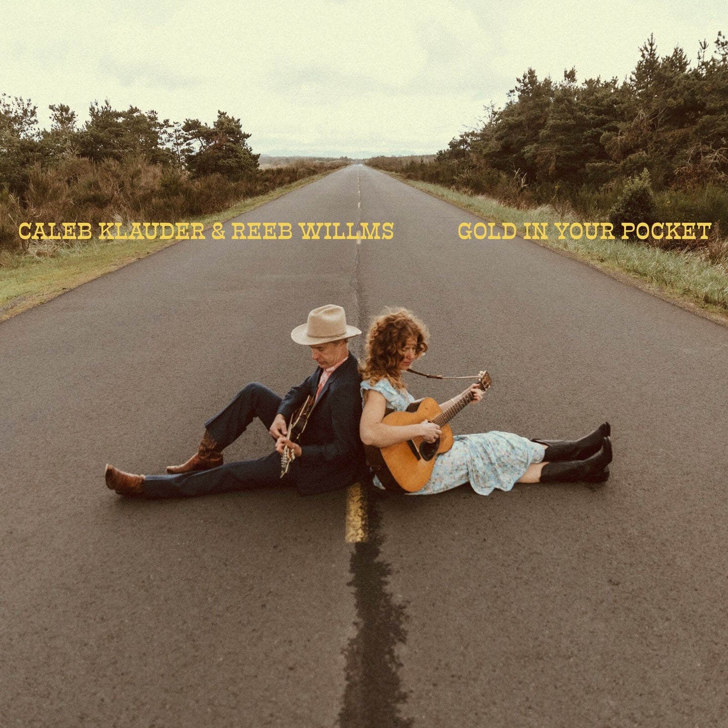 Album cover: musicians with guitars sitting on a rural road.