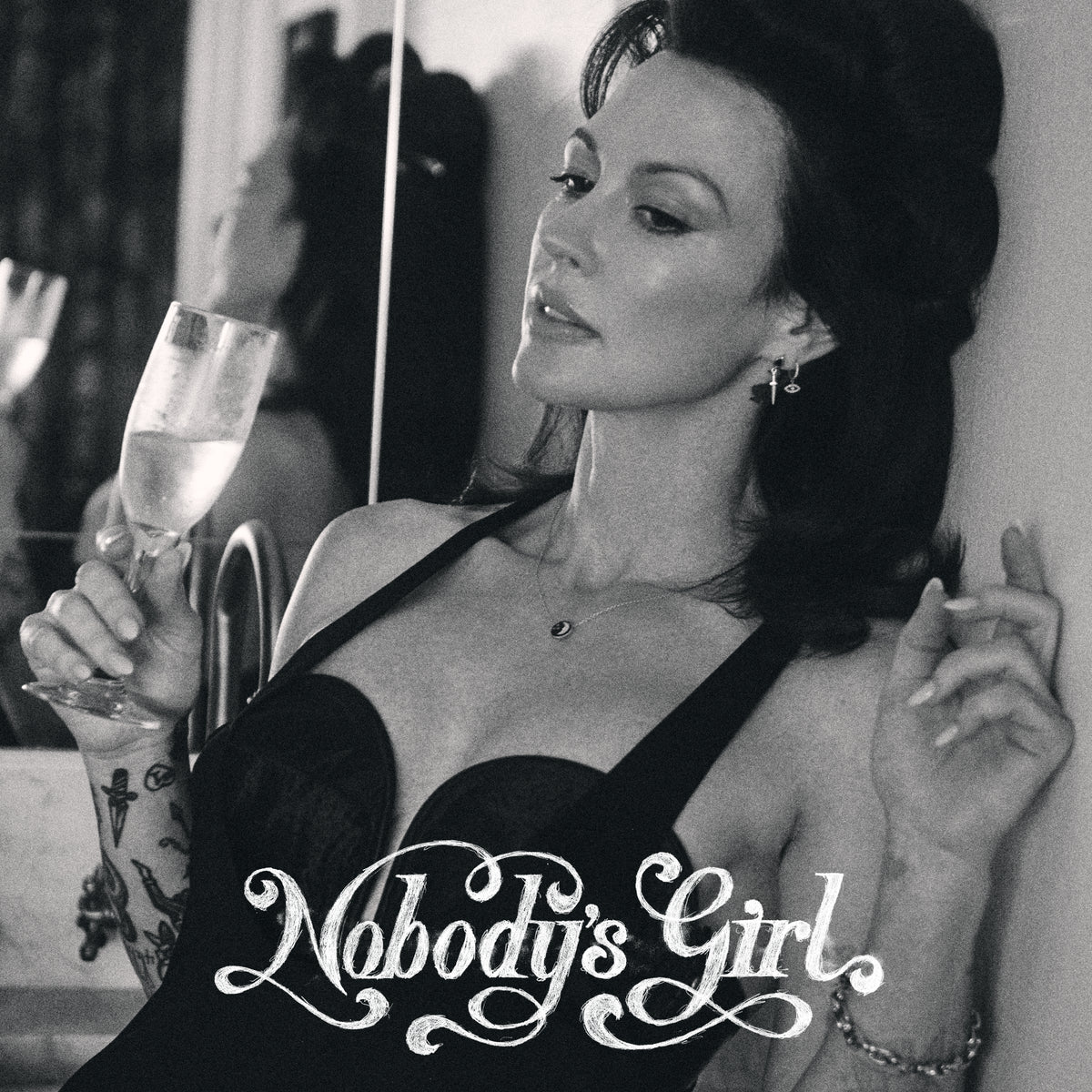 Black and white portrait of Amanda Shires holding a drink.