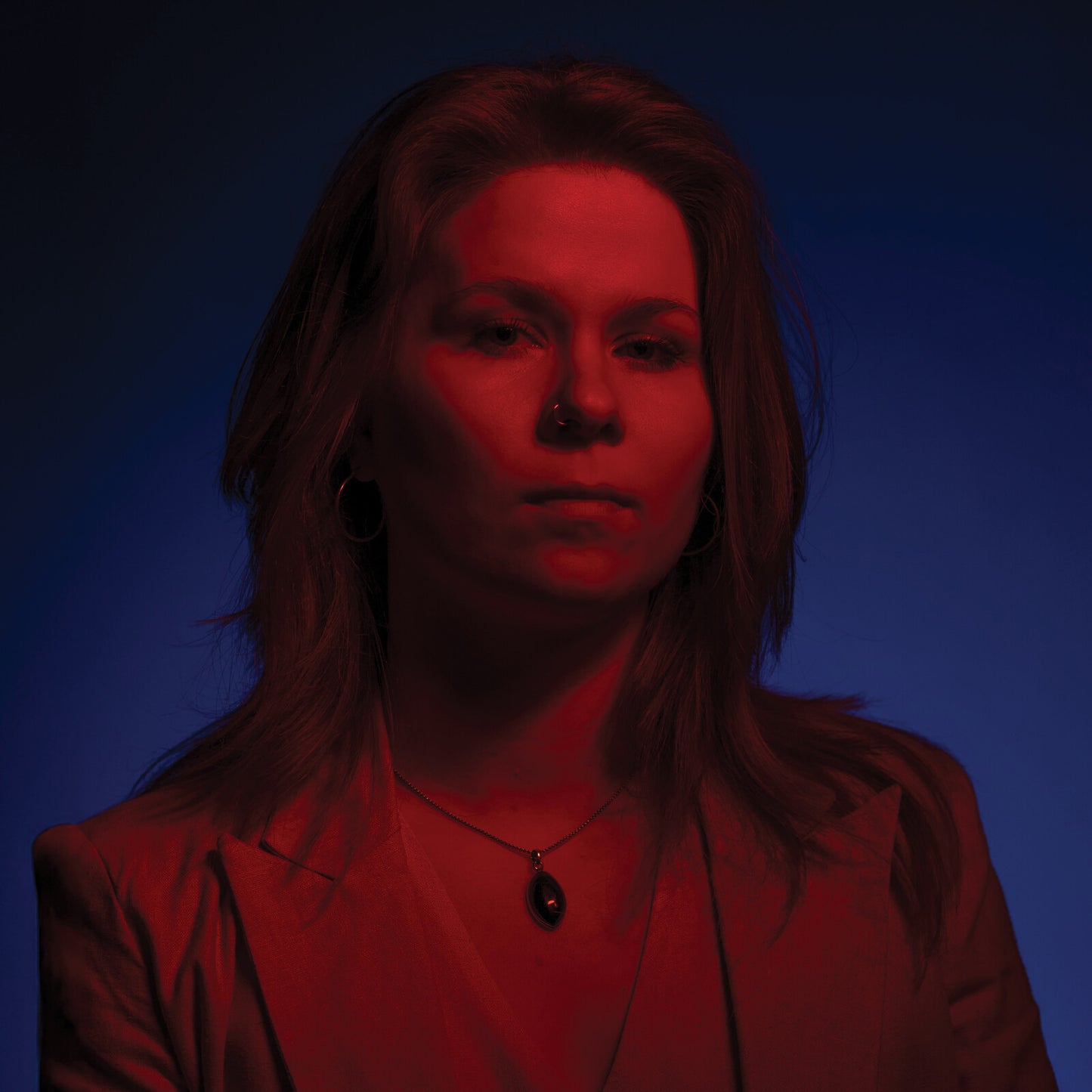 Close-up portrait of Katie Spencer with red and blue lighting.