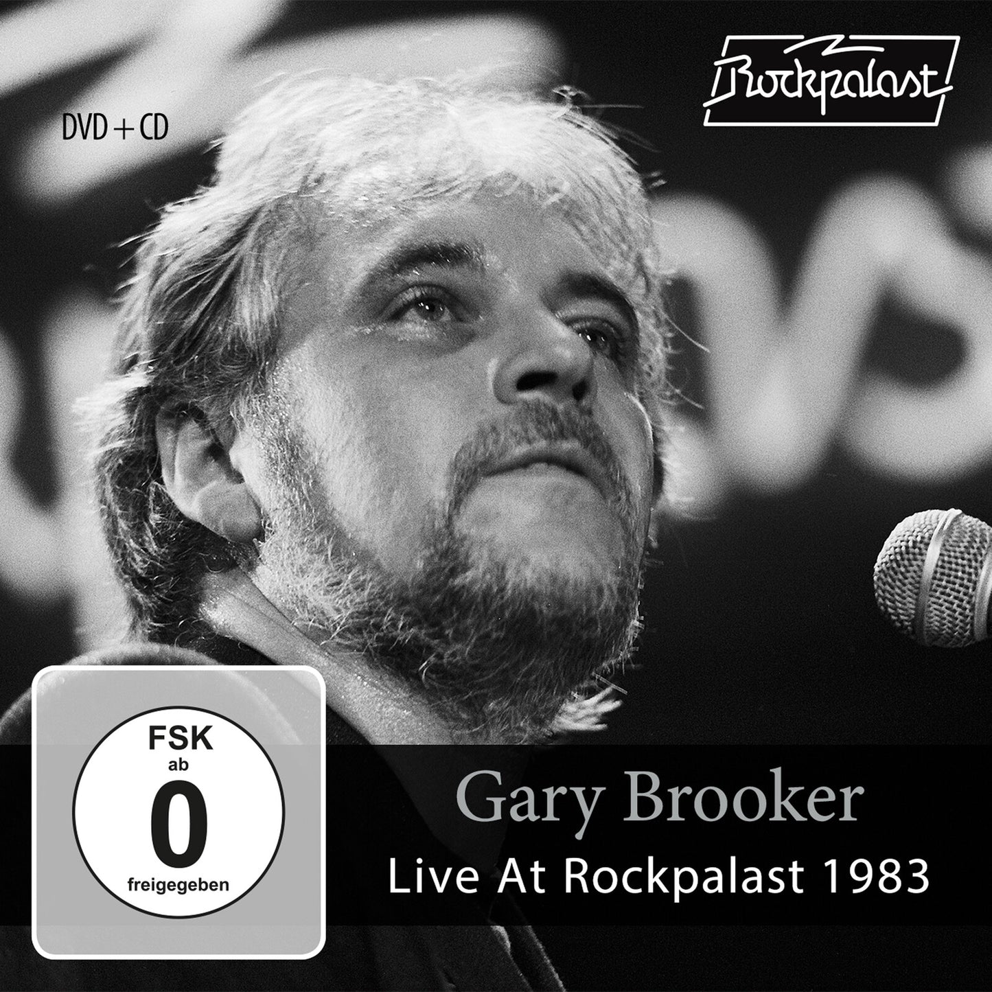 Black and white portrait of Gary Brooker singing into a microphone.