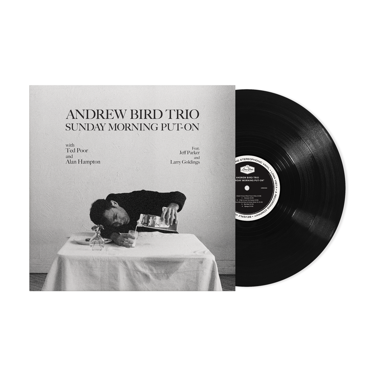 Black vinyl record next to its black and white album cover art.