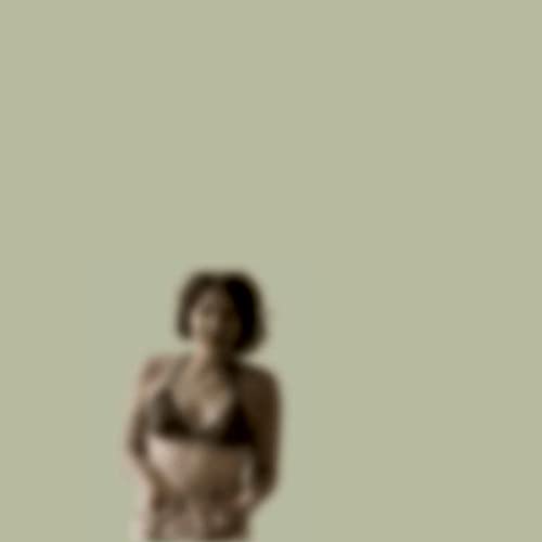 Blurred image of a person with short hair against a pale background.