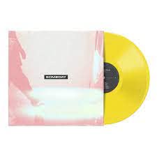 Yellow vinyl record with abstract pink and blue album cover art.