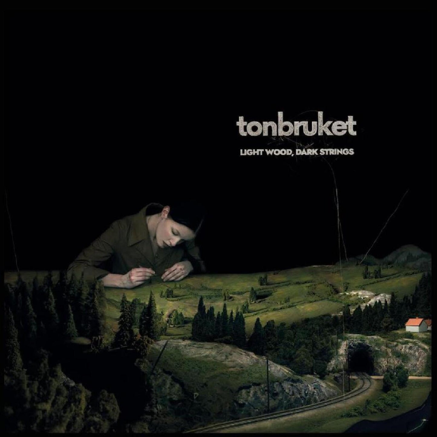 CD cover: woman with miniature landscape and train track scene.