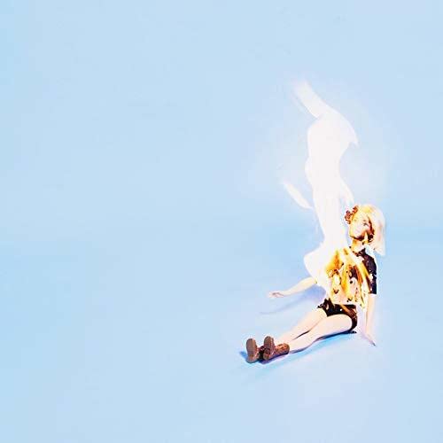 Doll sitting amidst flames against a pale blue background.