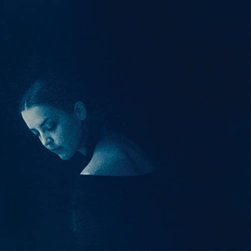Dark blue album cover featuring a woman with her head lowered.