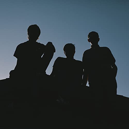 Silhouettes of three people against a gradient blue sky.