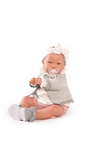 A realistic baby doll wearing a grey cardigan, patterned top, and headband with a pacifier.