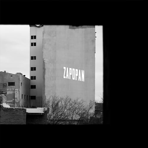 Black and white photo of a building with the word "Zapopan" painted on it.