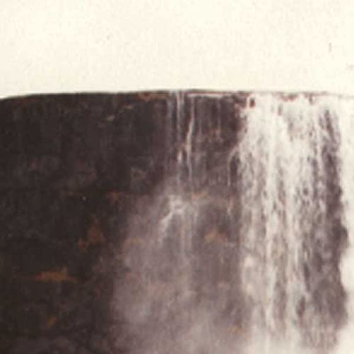 Close-up of a dark, textured surface with cascading white lines.