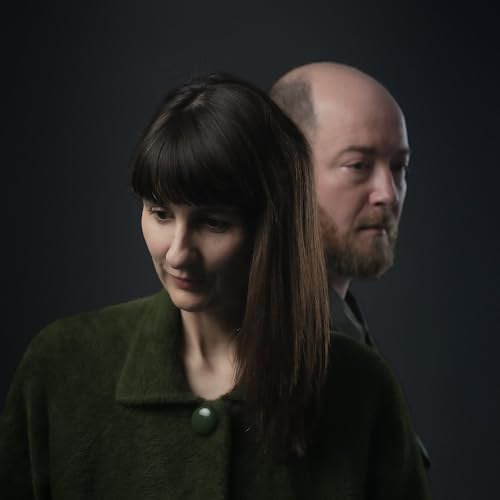 Two people, a woman and a man, in a studio portrait.