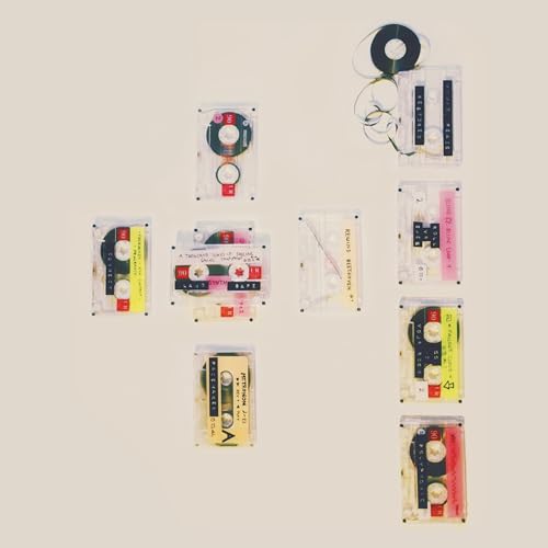 Arrangement of vintage cassette tapes against a pale beige background.