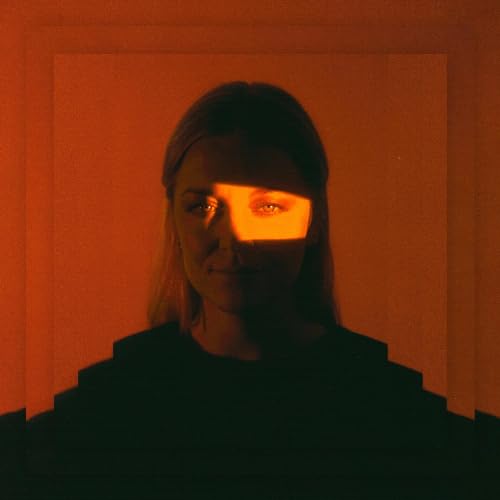 Woman’s portrait with warm orange lighting and strong shadows.